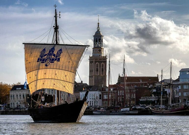 De Kamper Kogge vaart voor het stadsfront van Kampen met de Nieuwe Toren langs