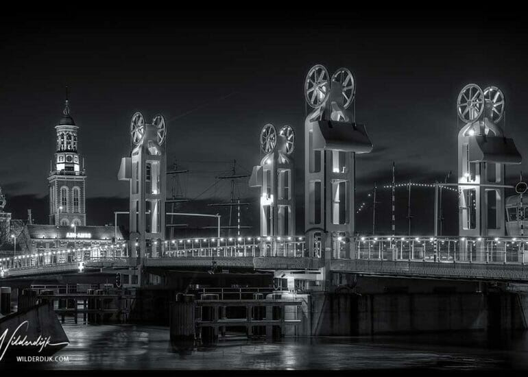 Zwart en wit foto van de stadsbrug als onderdeel van het stadsfront van Kampen bij avond