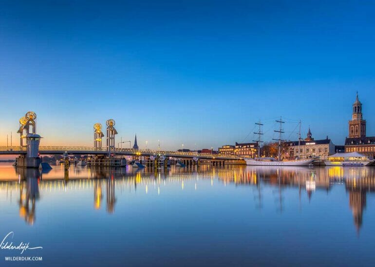 Stadsfront van Kampen met weerspiegeling in de IJssel bij een wolkeloze zonsopkomst