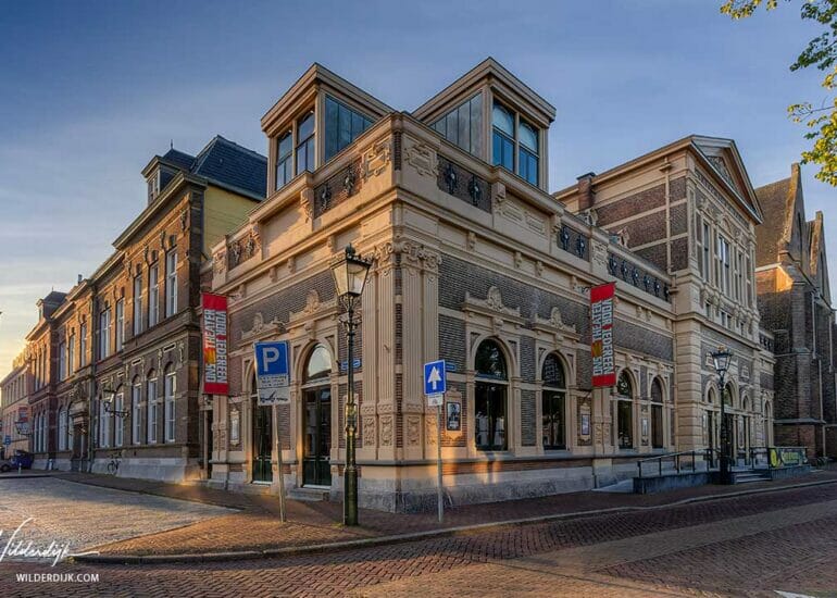 De Stadsgehoorzaal in Kampen, met de nieuwe Toren op de achtergrond, 's morgens direct na zonsopkomst