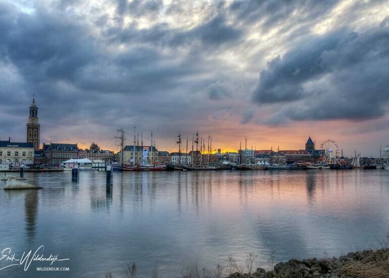 Mooie gekleurde zonsondergang met een bewolkte lucht boven het stadsfront van Kampen tijdens Sail 2018