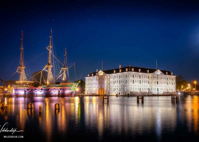 Scheepvaartmuseum en maritiem museum Amsterdam bij avond met volle maan
