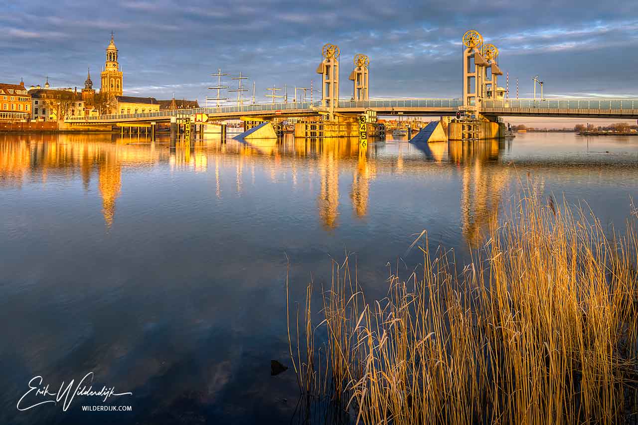 Het IJsselfront van Kampen met de stadsbrug en Nieuwe Toren in het gouden zonlicht direct na zonsopkomst