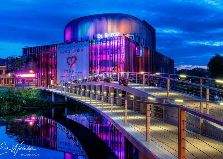 Avondfoto van het paars aangelichte theater de Spiegel in Zwolle